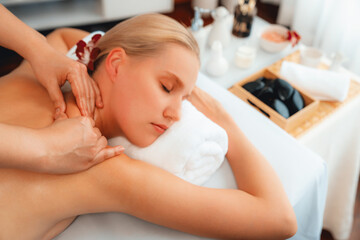 Caucasian woman customer enjoying relaxing anti-stress spa massage and pampering with beauty skin recreation leisure in day light ambient salon spa at luxury resort or hotel. Quiescent
