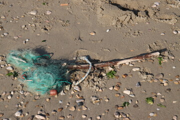 Fishing net and rope polluting sandy beach