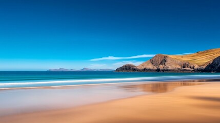 A tranquil beach scene with smooth sands and calm waves, under a clear blue sky