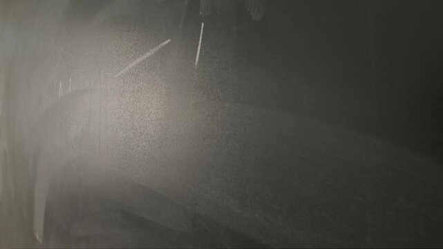 Close up of woman hand wiping text math test on chalkboard, professor writes on blackboard or student solving task. Education and science concept.