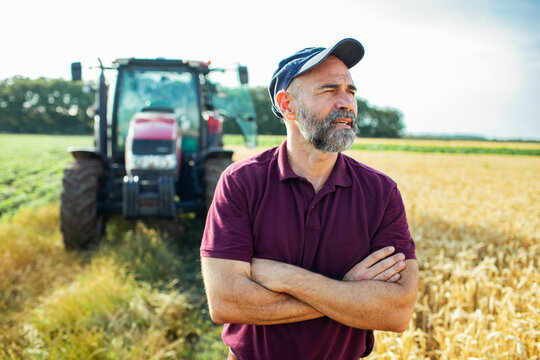 Portrait of a middle aged male farmer next to tractor