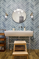 Bathroom with cyan tile and washstand, round mirror