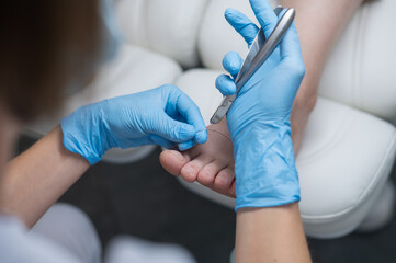 Hands in blue medical gloves folded in the shape of a heart on a white background. Foot care. Podologist