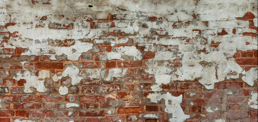 Fragment of an old wall made of old brick with partially peeled white plaster. Panorama. Background. Texture.