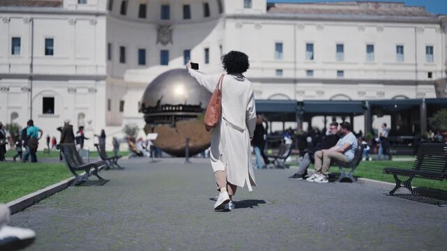 Vatican, Rome, Italy - 25 May, 2024: Woman tourist taking photos at Vatican's Sphere within Sphere