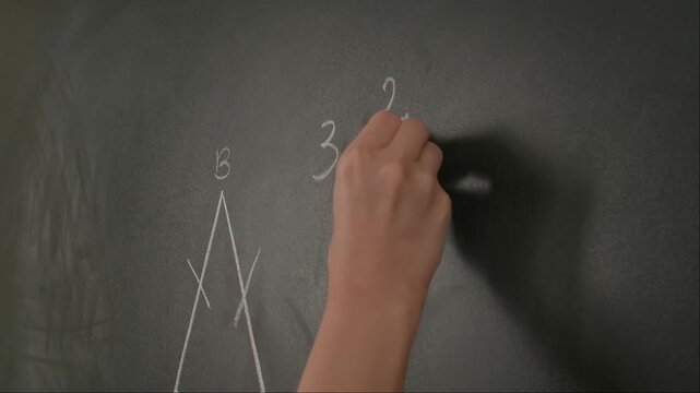 Close up of woman hand writing text and trigonometry formulas on chalkboard, professor writes on blackboard or student solving task. Education and science concept.