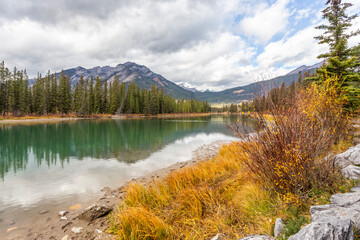 Autumn view of calm water lake and mountains range in the background. Bow River in Banff, Alberta,...