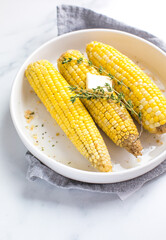 Grilled corn on cob sprinkled with butter