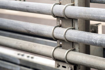 Fototapeta premium metallic pipes secured to a pole with curved threaded brackets, highlighting the interplay of industrial design and functionality