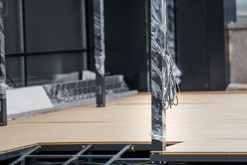 bundle of fresh wires rests on a new metallic pole, wrapped in plastic, symbolizing the beginnings...