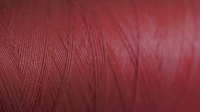 Spool of crimson cotton thread for sewing macro