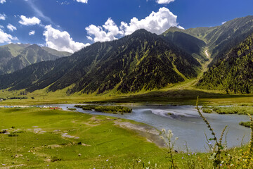 Beautiful mountain scenery. River, valley, snow, blue sky, white clouds. In-depth trip on the Sonamarg Hill Trek in Jammu and Kashmir, India