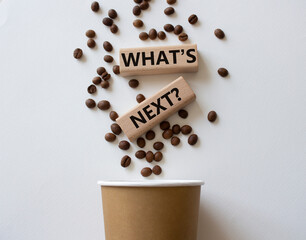 What is next symbol. Concept words What is next on wooden blocks. Beautiful white background with coffee cup and coffee beans. Business and What is next concept. Copy space.