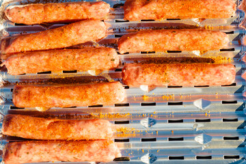 Sausages meat grilling on gas grill