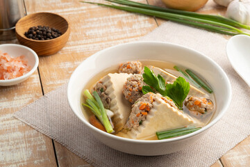 Clear Soup with flat Tofu stuffed with seasoning minced pork in white bowl. ( Kang Jued Tao Hoo Moo Sub)