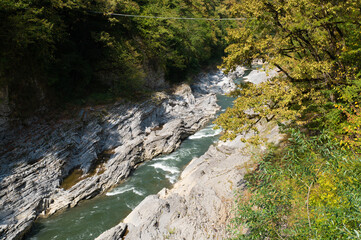 Mountain river with transparent foamy water and rocky bottom