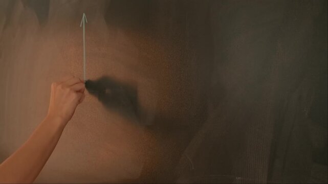 Close up of woman hand drawing coordinate axis with parabola on chalkboard, professor writes on blackboard or student solving task. Education and science concept.