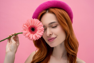 Smiling dreamy cute young woman with a flower
