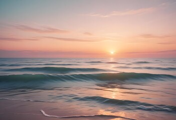Obraz premium A serene ocean landscape with calm, rippling waves reflecting the warm, pastel-colored sky and bright sun in the distance