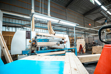woodworking factory with an automated machine processing wooden boards on a conveyor belt under...