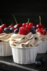 Tasty cupcakes with different berries on table, closeup
