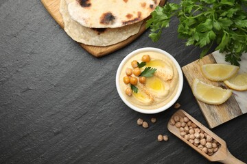 Delicious hummus with olive oil and chickpeas served on grey textured table, flat lay. Space for text