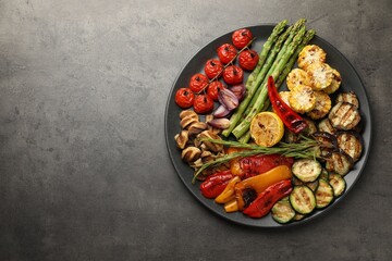Delicious grilled vegetables on grey textured table, top view. Space for text