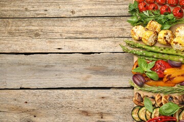 Delicious grilled vegetables and spices on wooden table, top view. Space for text