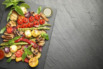 Delicious grilled vegetables with spices on grey textured table, top view. Space for text