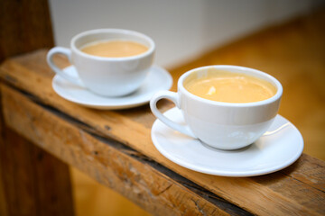 Two cups of hot coffee crema on a rustic bar in an old German café; coffee house with tasting