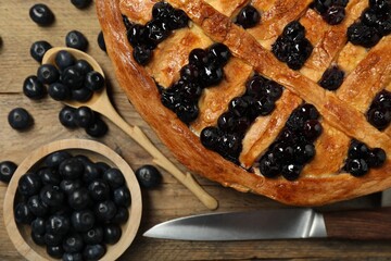 Tasty homemade pie with blueberries served on wooden table, flat lay