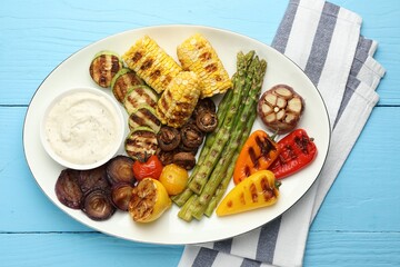 Delicious grilled vegetables with sauce on light blue wooden table, top view