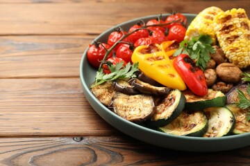 Delicious grilled vegetables on wooden table, closeup