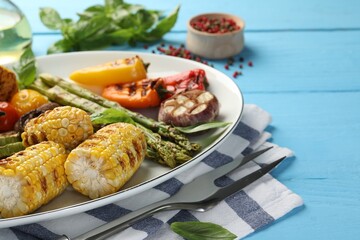 Delicious grilled vegetables served on light blue wooden table, closeup