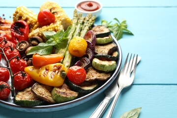 Delicious grilled vegetables served on light blue wooden table, closeup