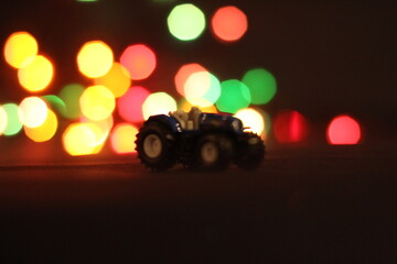 zabawkowy traktor na tle rozmazanych świateł © Oskar