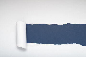 Torn white paper revealing a blue-gray background. Space for text.