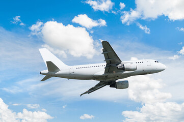 Airplane flying in the sky, travel background with commercial white flying airplane flying in the sky among dense white clouds