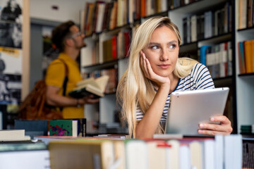 A young woman engages with a digital tablet, her expression content, while a man selects books in a library setting, both immersed in their academic pursuits.