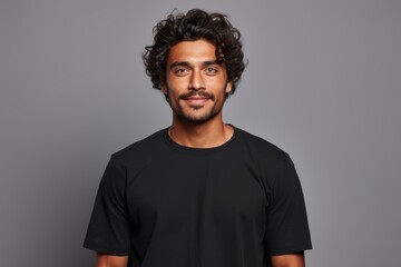 Fototapeta premium People positive emotions concept. Studio waist up of young happy smiling broadly Hindu man standing in centre isolated on white background wearing black casual t shirt looking straight at camera