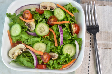 cucmbers, tomatoes  onions and mushrooms  in this garden salad
