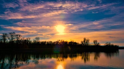 Obraz premium Purple sunset above the lake with colorful clouds