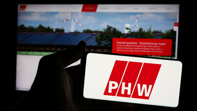 Stuttgart, Germany - 08-05-2024: Person holding mobile phone with logo of German meat processing company Lohmann Co. AG (PHW-Gruppe) in front of web page. Focus on phone display.