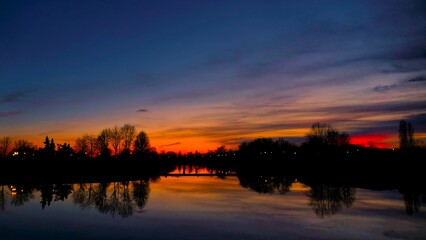 Naklejka premium Purple sunset above the lake with colorful clouds