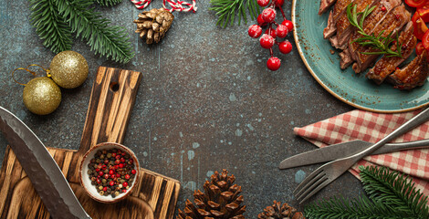 Festive Christmas dinner boarder background with space for text with roasted duck breast fillet with golden crispy skin and tomato salad, Xmas decorations with fir tree, cones, red berries..