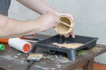 A man is painting a wall with a can of paint