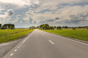 A long road with a few trees in the background
