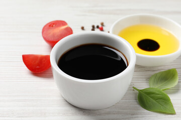Balsamic vinegar, oil and other products on white wooden table