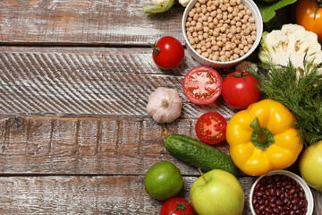 Different vegetarian products on wooden table, top view. Space for text