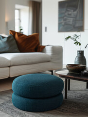 A modern and cozy living room with a blue pouf and decor.
